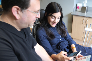 Dentist showing phone to patient