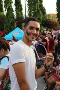 Image of a young person in a white tee and pride face paint
